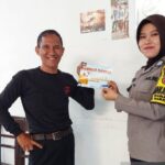 Bhabinkamtibmas Menyebarluaskan Brosur Seruan Pemilu Damai